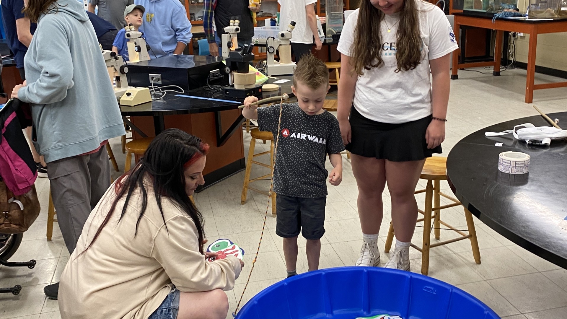 Child doing a fishing activity at World Oceans Day 2024