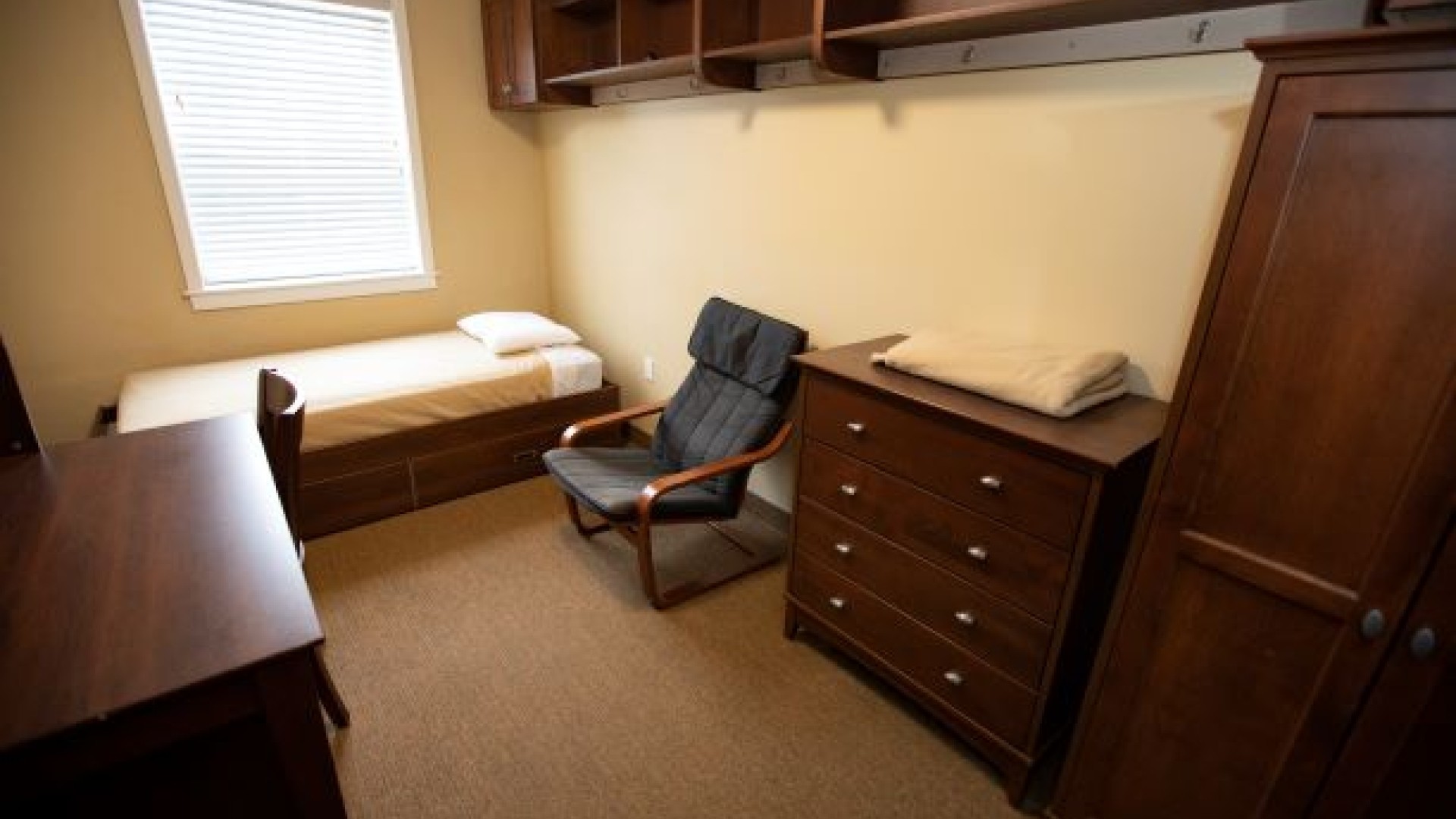 Single furnished room in Bishops Hall with desk, chair, bed, dresser and closet