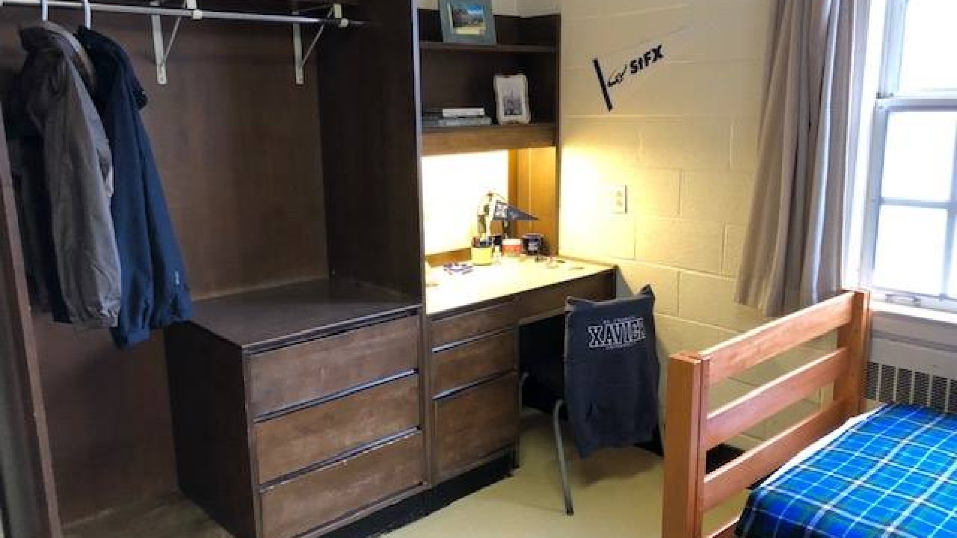 Double room in FX Hall showing one of two beds, dressers, and closet.