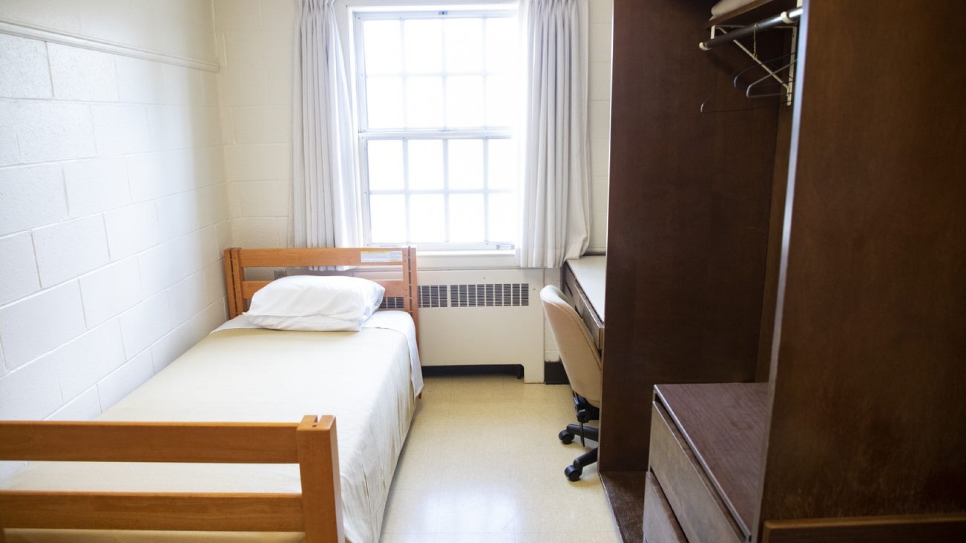 Single room in FX Hall with a bed, desk, and closet