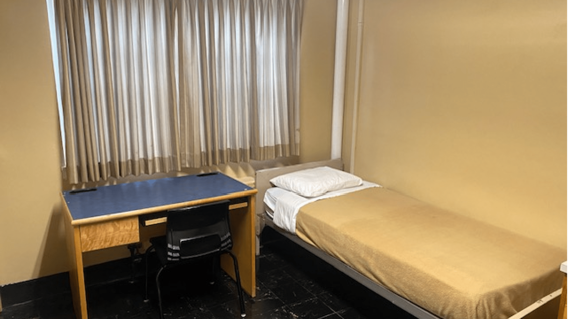 A single room in Cameron Hall with a bed and desk