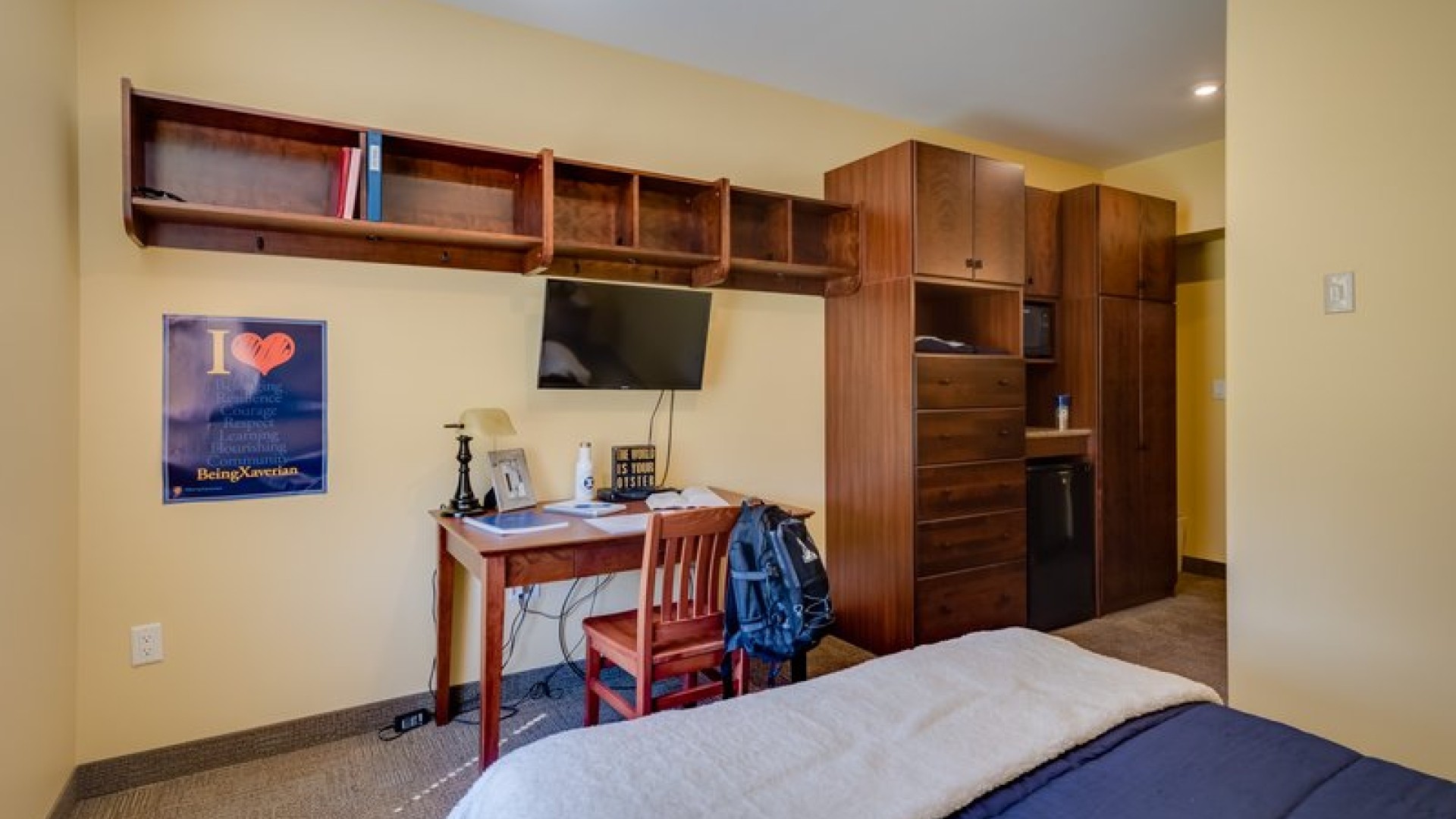 An O'Regan/Riley Single suite showing a desk, storage, closet, mini-fridge, and microwave.