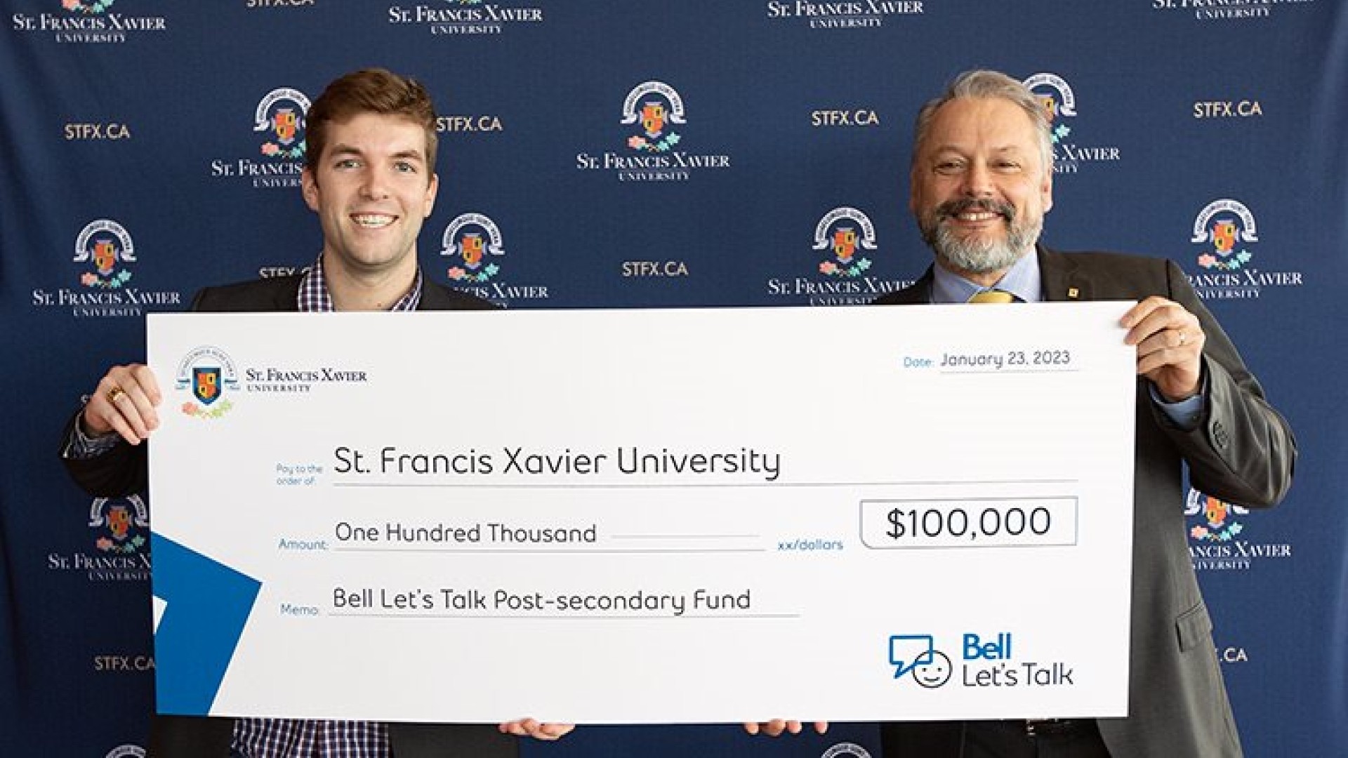 StFX Students Union VP External, Ben Fairhurst and StFX President Dr. Andy Hakin holding up a $100,000 cheque from Bell Let's Talk Day.