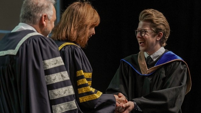 A Class of 2025 student shakes hands with Chancellor, Dr. Mila Mulroney