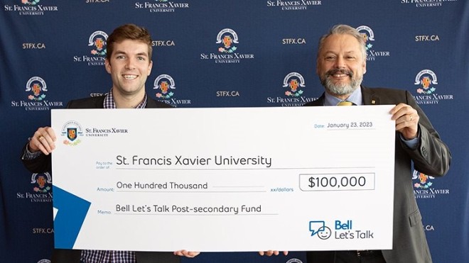 StFX Students Union VP External, Ben Fairhurst and StFX President Dr. Andy Hakin holding up a $100,000 cheque from Bell Let's Talk Day.