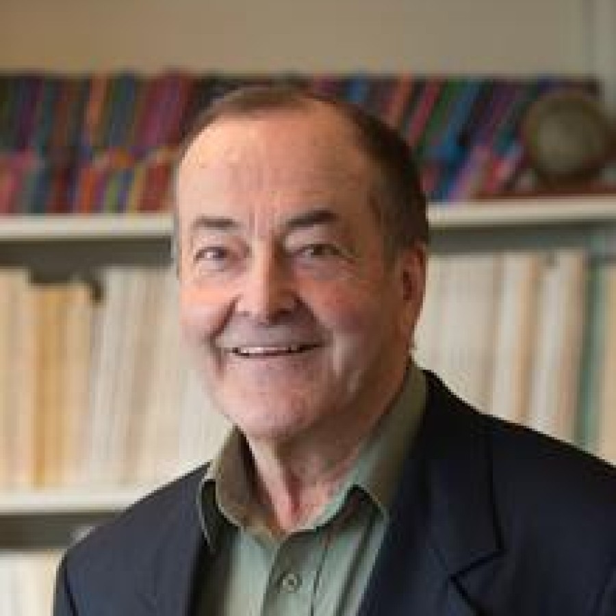 A person in front of a bookcase smiling