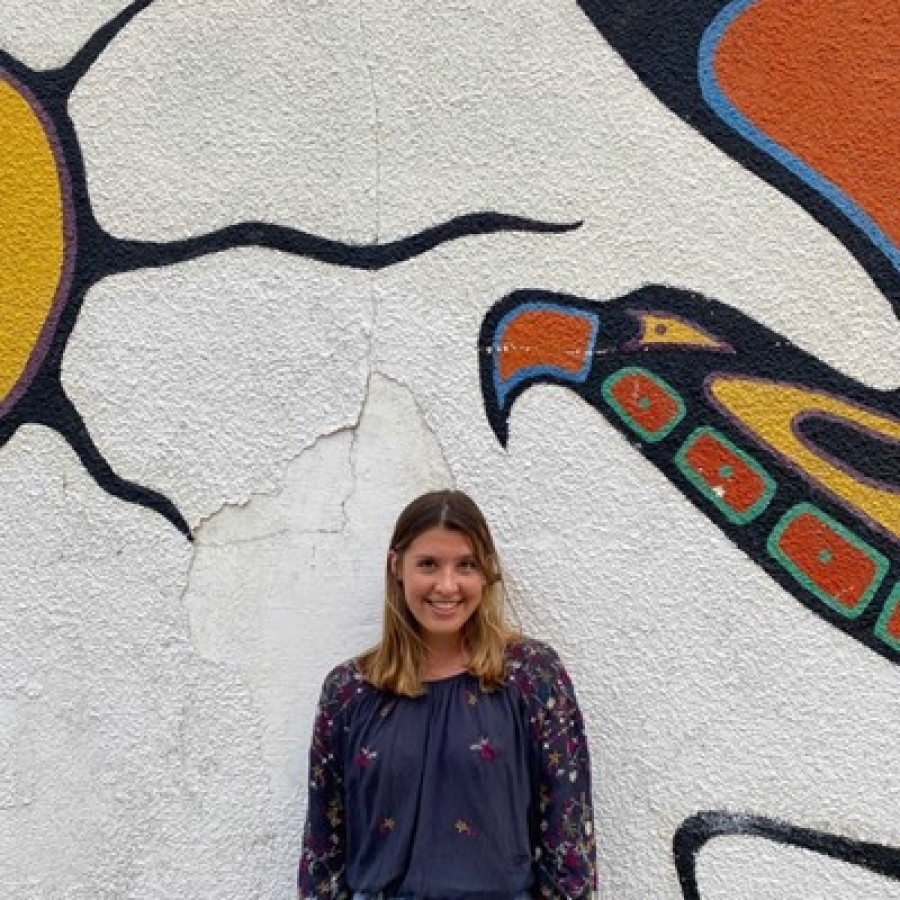 Chloe Walker standing in front of a mural