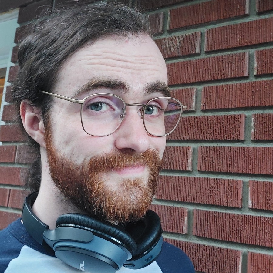 Headshot of a man with headphones around his neck