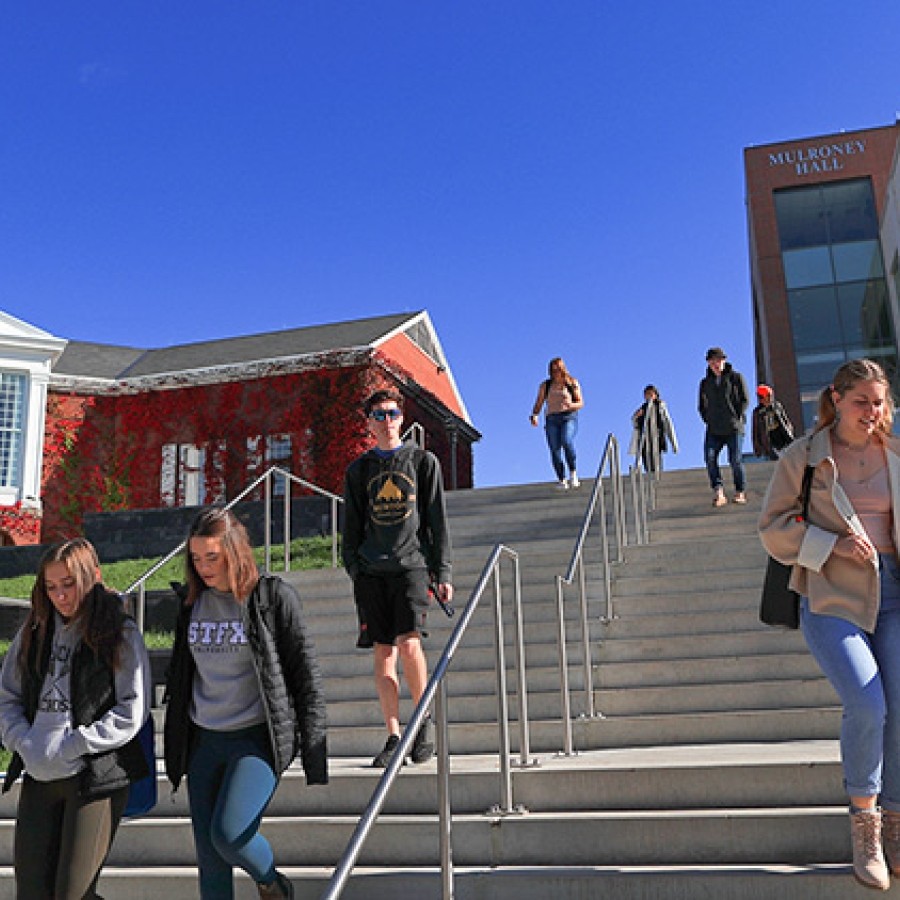 Students walking down steps in front of Mulroney Hall and Angus L. Library.
