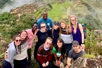 Group of people posing in front of Machu Picchu