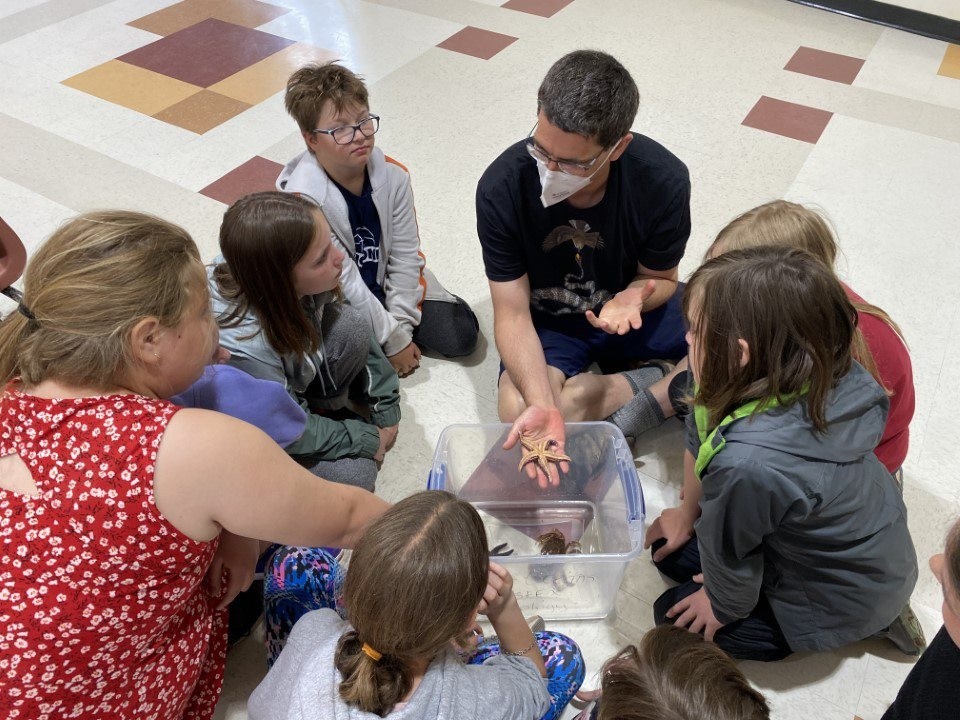 School Teacher Instructing Students on Starfishes