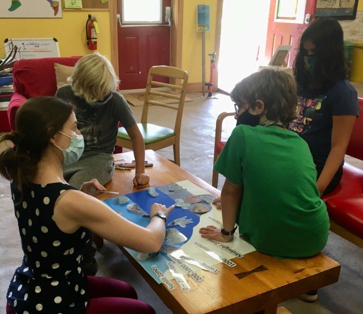 Students at a Table Creating a Poster About Biology Topic