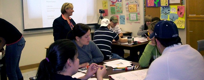 Students in a classroom gathered in groups of 4