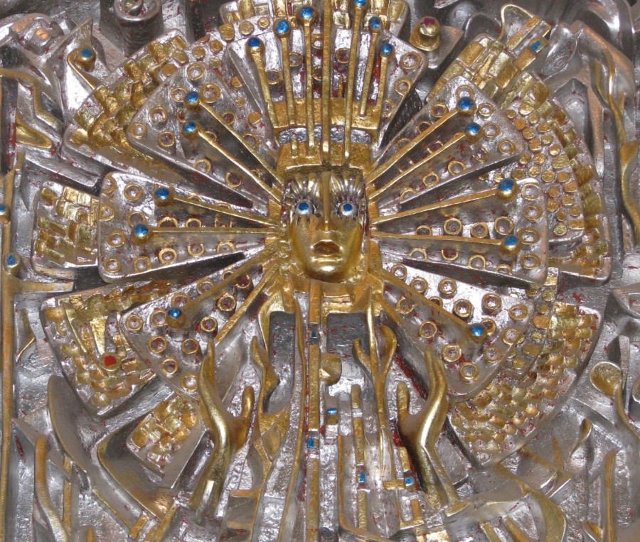 A carved gold-painted panel featuring religious symbolism.