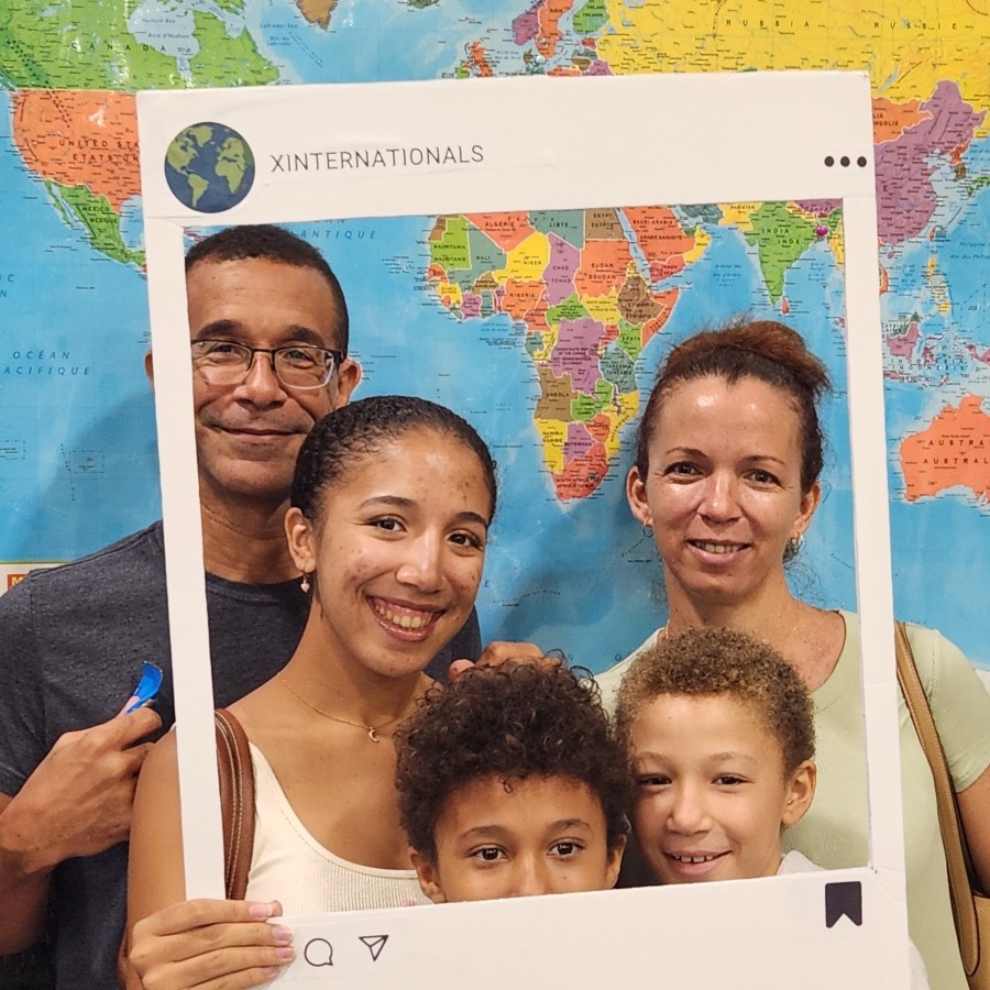 A student and family stand in front of a map of the world