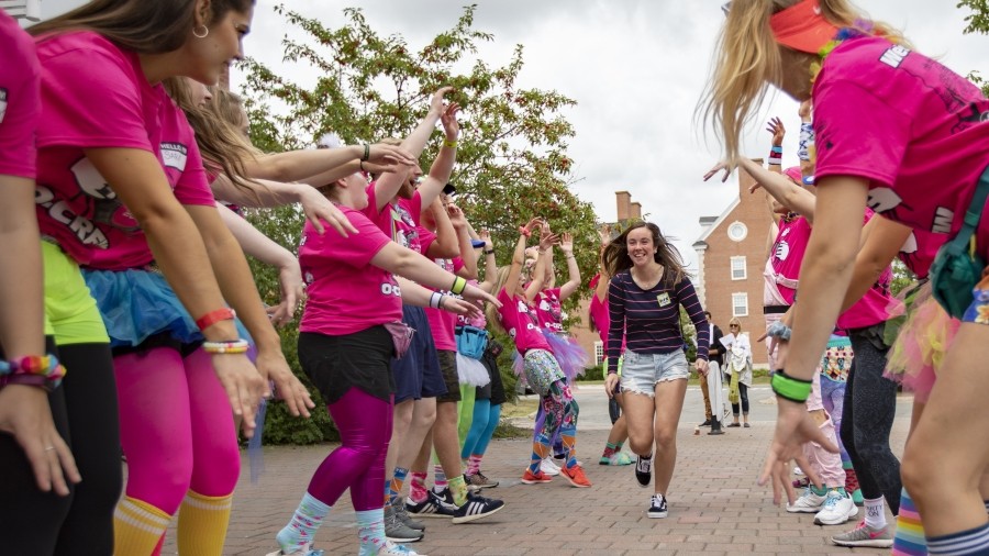 Student being welcomed by O-Crew on welcome day by running through the tunnel created by O-Crew members.