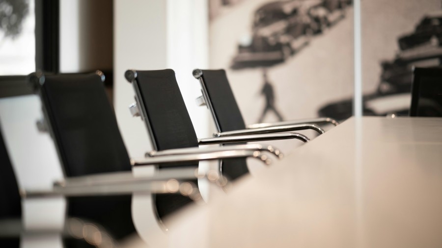 Conference room table with black office chairs around it.