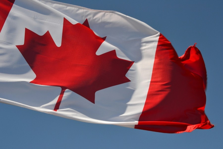 Canadian flag against a blue sky.