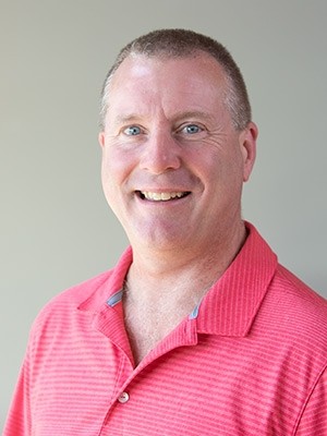Person wearing pink shirt, smiling