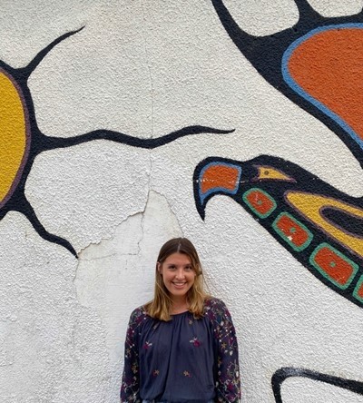 Chloe Walker standing in front of a mural