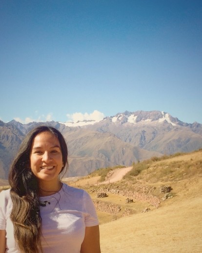 Person smiling standing in front of a desert