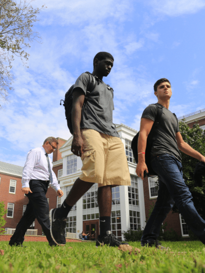 Two business students and a professor walking outside of the Gerald Schwartz School of Business